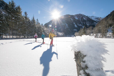 Begleitet von der strahlenden Sonne warten 3 Personen durch den Schnee | © Gerhard Pilz